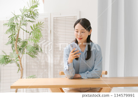 一個操作智能手機的年輕女子 134579991