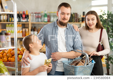 Young family with little son choosing products in supermarket Young family with little son choosing products in supermarket 134580064