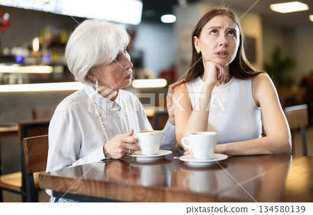 Meeting at cafe, elderly woman comforts his daughter 134580139
