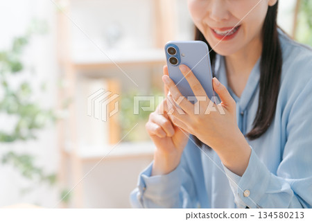 A young woman operating a smartphone A young woman operating a smartphone 134580213