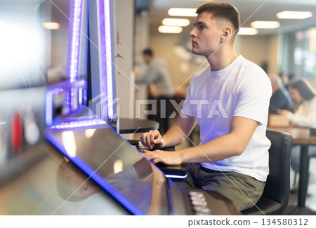guy plays a slot machine with video games guy plays a slot machine with video games 134580312