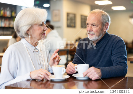 Senior spouses in cafe, chat and joke, flirting, eat and drink coffee Senior spouses in cafe, chat and joke, flirting, eat and drink coffee 134580321