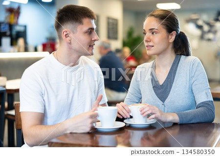 Girl in cafe sits near guy companion, has nice conversation Girl in cafe sits near guy companion, has nice conversation 134580350