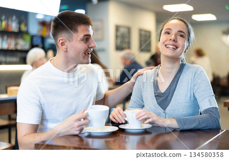 Girl in cafe sits near guy companion, has nice conversation 134580358