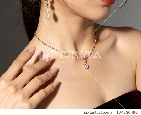 一位日本女性佩戴著閃亮的鑽石項鍊，露出迷人的鎖骨。這是美容、珠寶和高端美容院的廣告宣傳資料。 134580496