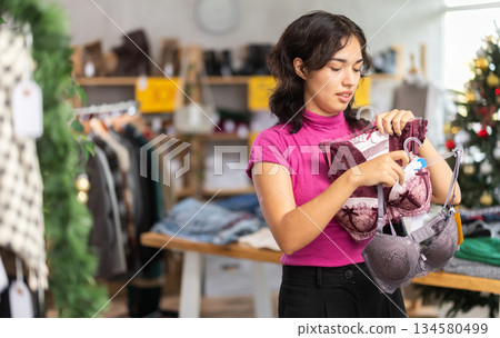Asian woman chooses underwear or bra in clothing store before Christmas 134580499