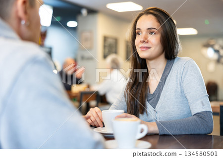 Young couple talking over a cup of coffee in a cozy cafe 134580501