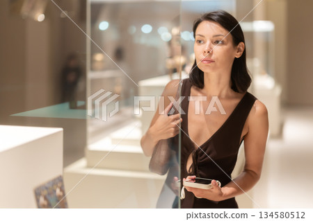 Woman looking at historical exhibits in museum 134580512