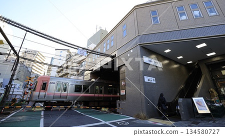 Shinsen Station on the Keio Inokashira Line, north exit with escalators and a moving train Shinsen Station on the Keio Inokashira Line, north exit with escalators and a moving train 134580727