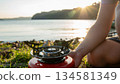 準備一個單爐灶，以便在湖邊日落時分露營。 134581349