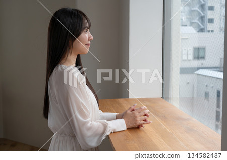 A woman looking out the window 134582487