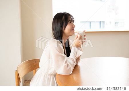 一個女人在一個房間裡喝茶 一個女人在一個房間裡喝茶 134582546