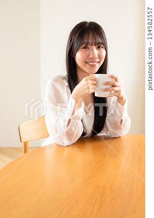 A woman drinking coffee 134582557