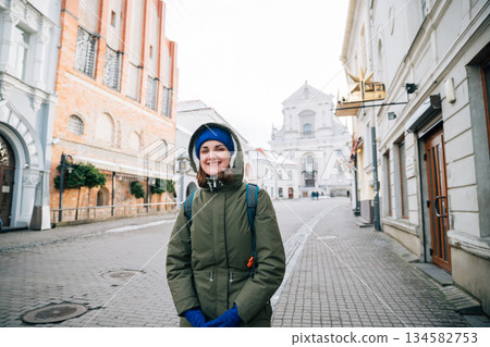 Vilnius, Lithuania. Young Beautiful Pretty Caucasian Girl Woman Tourist Smiling On Background St. Therese Church Vilnius, Lithuania. Young Beautiful Pretty Caucasian Girl Woman Tourist Smiling On Background St. Therese Church 134582753