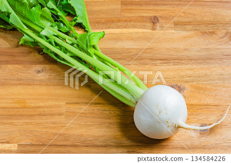 木桌上和竹籃裡擺放著新鮮的蘿蔔。 134584226