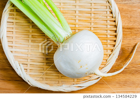 木桌上和竹籃裡擺放著新鮮的蘿蔔。 134584229