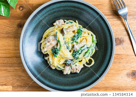 Spinach and mushroom cream pasta 134584314