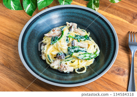 Spinach and mushroom cream pasta 134584318