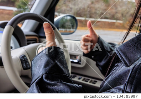 A scene of a woman in her 20s driving a car (no face) 134585997