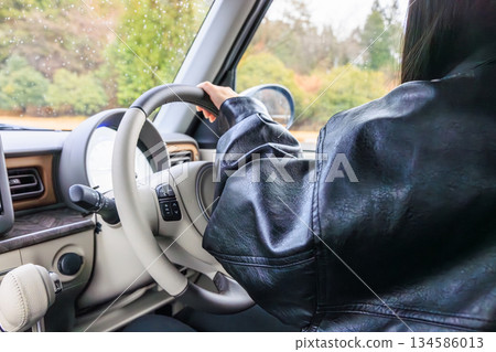 A scene of a woman in her 20s driving a car (no face) 134586013
