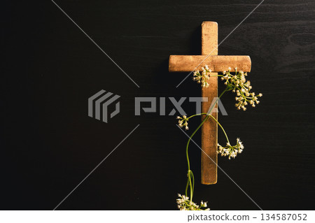 Wooden cross placed on dark background, symbolizing Christian faith, Palm Sunday, sacrifice, Easter reflection, religious concept for worship, prayer, church design. Wooden cross placed on dark background, symbolizing Christian faith, Palm Sunday, sacrifice, Easter reflection, religious concept for worship, prayer, church design. 134587052