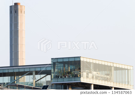 Factory chimneys and glass buildings at Hitachi Station 134587063