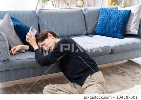 A woman falling asleep with her smartphone A woman falling asleep with her smartphone 134587301