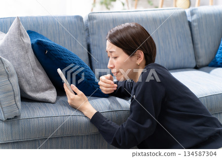 A woman watching a smartphone A woman watching a smartphone 134587304