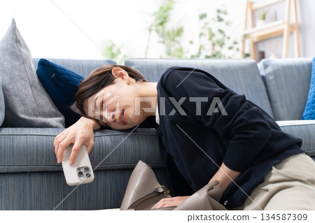 A woman falling asleep with her smartphone A woman falling asleep with her smartphone 134587309