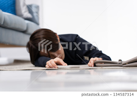 一名女子拿著智慧型手機跌倒了。 134587314