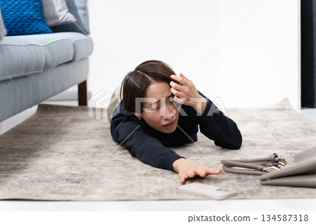 一名女子拿著智慧型手機跌倒了。 134587318