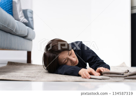 A woman falls down while holding a smartphone A woman falls down while holding a smartphone 134587319