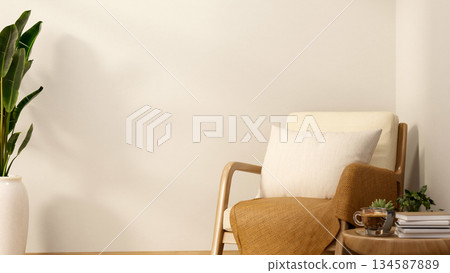 Wooden armchair with pillow and blanket aside table with book and coffee cup in a white wall room. 134587889