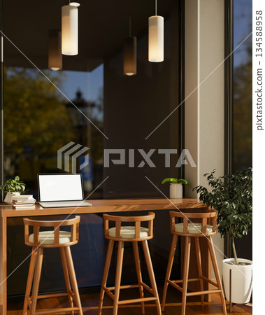 Blank screen laptop and books on a wooden counter with stool chairs under cafe's candle light lamp. Blank screen laptop and books on a wooden counter with stool chairs under cafe's candle light lamp. 134588958