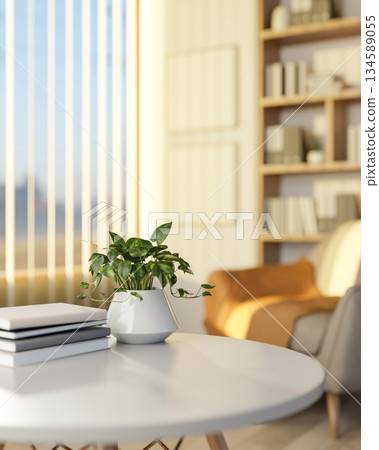 White round table with a potted plant and books in a living room with fabric sofa and a bookshelf. 134589055