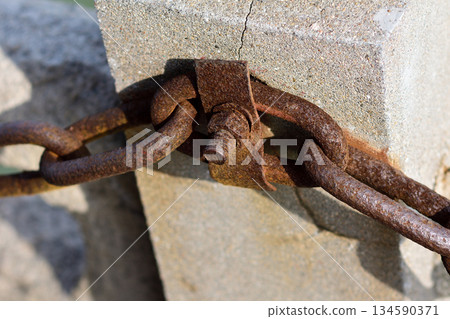 Rusty Chain Link on Concrete Block 134590371