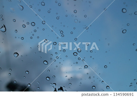 Sunset sky after the rain seen through a windshield with water droplets 134590691