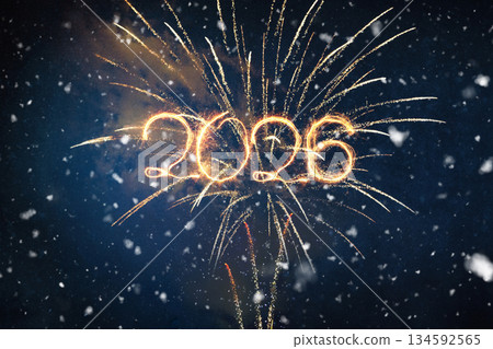 Bright 2026 text written with golden sparks or light trails, superimposed over a stunning fireworks display in a dark, snowy winter night sky. New Year celebration concept. Bright 2026 text written with golden sparks or light trails, superimposed over a stunning fireworks display in a dark, snowy winter night sky. New Year celebration concept. 134592565