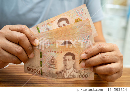 Asian woman counting Thai baht banknote money, investment economy, accounting business and banking. Asian woman counting Thai baht banknote money, investment economy, accounting business and banking. 134593824