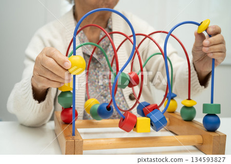 Asian elderly woman playing enhancing skill board game. Asian elderly woman playing enhancing skill board game. 134593827