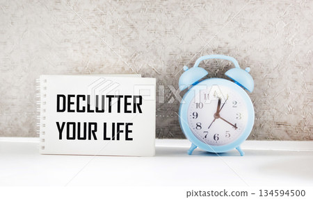 A notebook with the words DECLUTTER YOUR LIFE on a light background. business concept. A notebook with the words DECLUTTER YOUR LIFE on a light background. business concept. 134594500