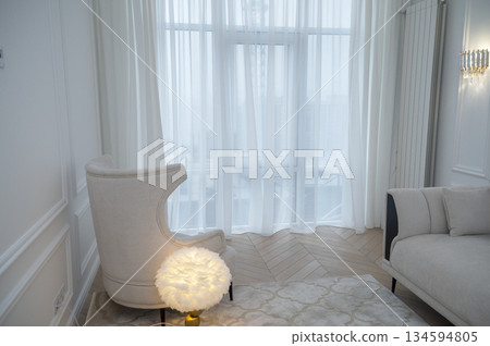 Modern style of the room interior, armchair, lamp, sofa, carpet, large window Modern style of the room interior, armchair, lamp, sofa, carpet, large window 134594805