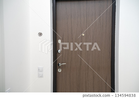 close-up of a wooden door with a metal handle. close-up of a wooden door with a metal handle. 134594838