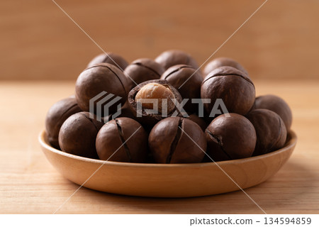 Macadamia nuts in a bowl on wooden background Macadamia nuts in a bowl on wooden background 134594859