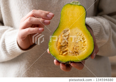 Half green butternut squash pumpkin holding by woman hand 134594880