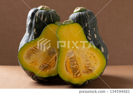 Half green butternut squash pumpkin on brown background 134594881