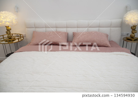double bed with white headboard and dark pink bed linen and white blanket 134594930