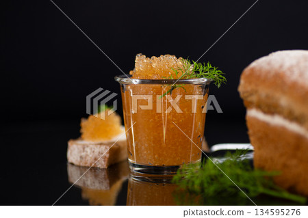 Fine dining presentation of golden caviar with aromatic fresh herbs Fine dining presentation of golden caviar with aromatic fresh herbs 134595276