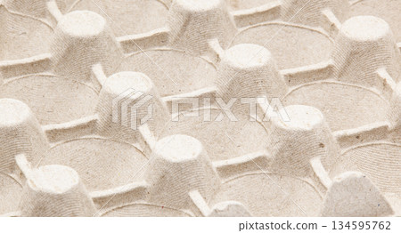 Abstract macro texture of empty papier-m ch egg packaging. Environmentally friendly recycled paper material, concept of recycling, sustainable development, and organic products. Abstract macro texture of empty papier-m ch egg packaging. Environmentally friendly recycled paper material, concept of recycling, sustainable development, and organic products. 134595762