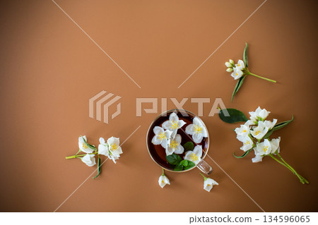 Jasmine and green tea in a transparent teapot close-up on a brown background Jasmine and green tea in a transparent teapot close-up on a brown background 134596065